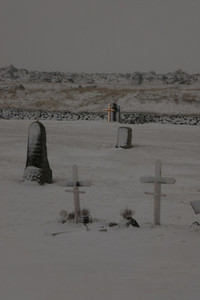 Snowy cemetery gravestones and crosses