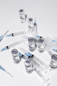 COVID 19 vaccine vials and syringes on white background
