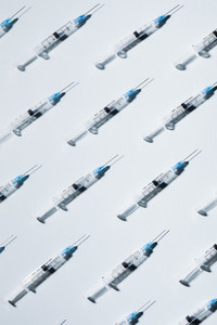 COVID 19 vaccine syringes on blue background