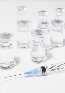 COVID 19 vaccine vials and syringe on white background