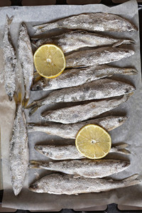 Salted whole fish and lemon slices on parchment paper