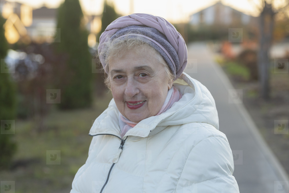 Portrait happy beautiful senior woman in winter coat on sidewalk