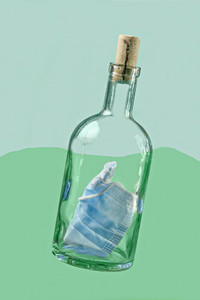 Protective face mask inside bottle with cork