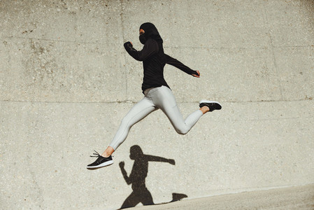 Woman running and jumping in sportswear