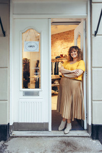 Businesswoman standing at entrance of her store