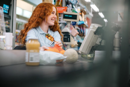 Woman working at grocery store checkout