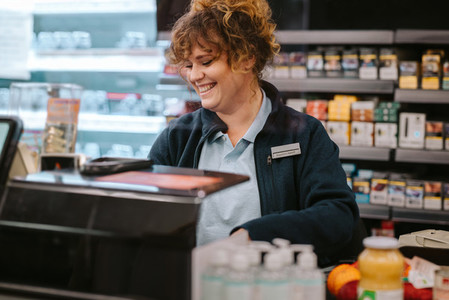 Happy female cashier working at a supermarket