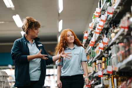 Supermarket manager giving training to a trainee employee
