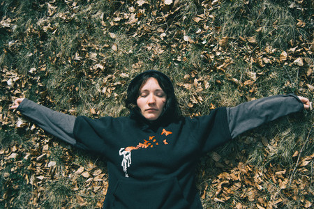 A girl with closed eyes lying down resting in nature