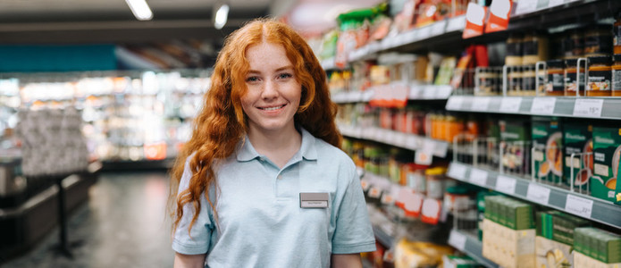 Happy saleswoman in modern supermarket
