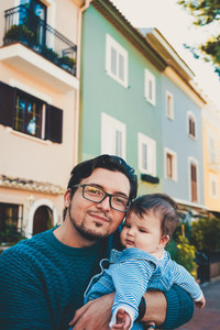 Adorable portrait of a young father hugging his baby
