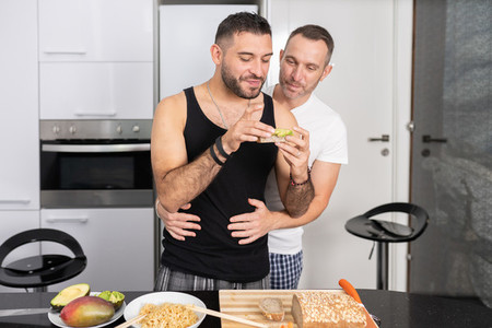 Gay couple cooking healthy vegan food together at home