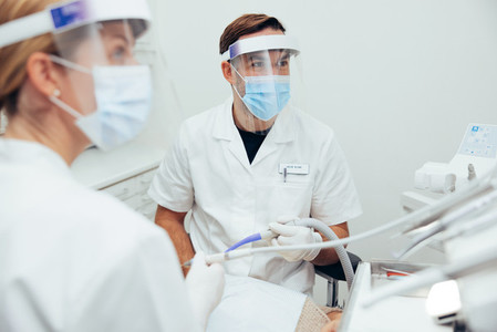 Dentists treating a patient with face shields