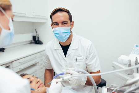 Successful dentist working on patients teeth
