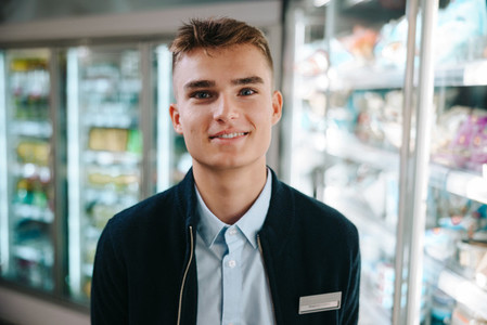 Young salesman in modern supermarket