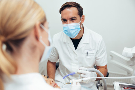 Dentist discussing with assistant during a treatment