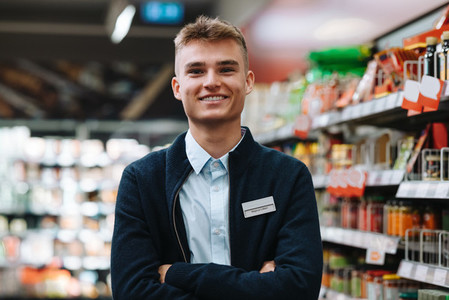 Confident young supermarket worker