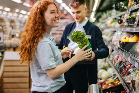 Young workers packing fresh produce on the shelves