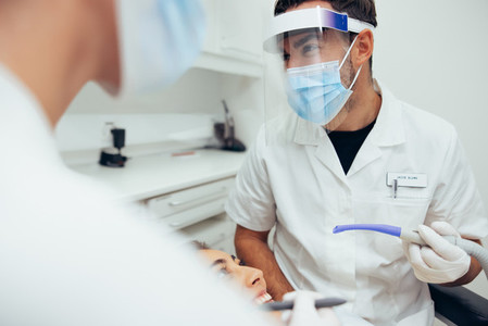 Dentist discussing with assistant during treatment