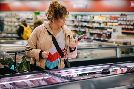 Customer reading product information at supermarket