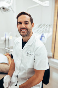 Happy young dentist in his clinic