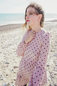 Young woman wearing a pink dress at the beach