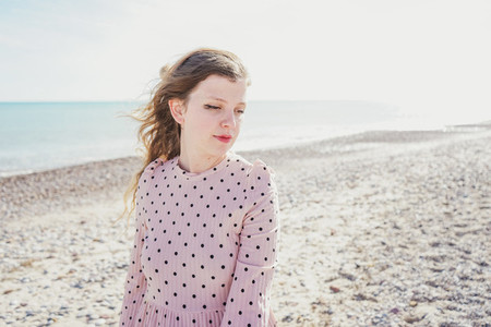 Young woman wearing a pink dress at the beach