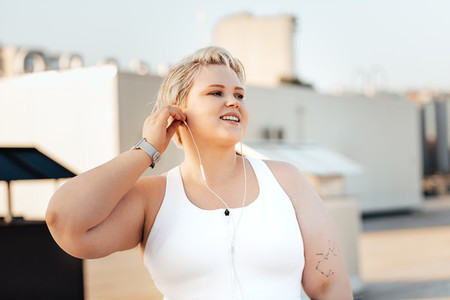 Happy curvy woman standing on a roof  Young oversized female taking a break