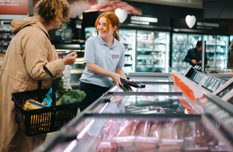 Supermarket worker assisting a customer