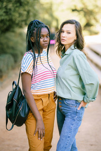 Two Multiethnic women looking at camera together on the street