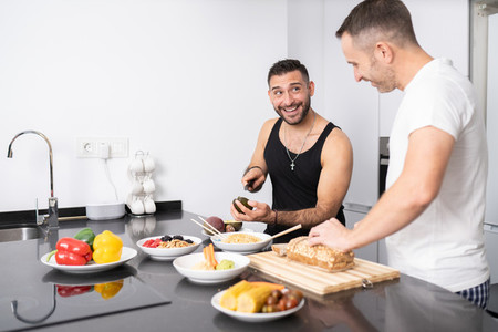 Gay couple cooking healthy vegan food together at home