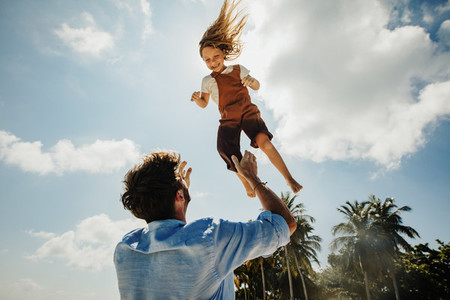 Father throwing daughter in air