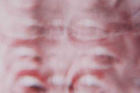Distorted image of a young woman face view througn a prism