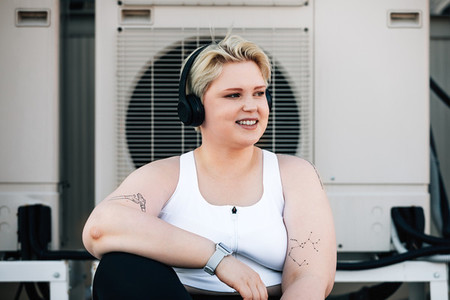Portrait of a plus size woman in sportswear taking a break during a workout on a roof