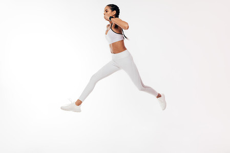 Woman athlete jumping on a white