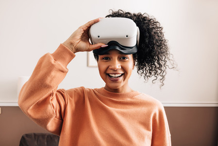 Portrait of mixed race woman holding a VR glasses looking at camera
