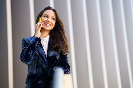 Business woman wearing blue suit using smartphone in an office building