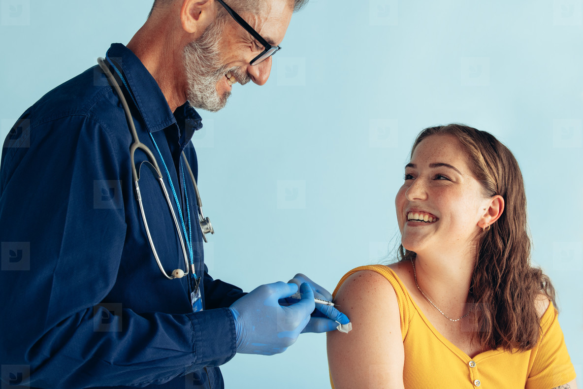 Friendly doctor giving vaccine to woman