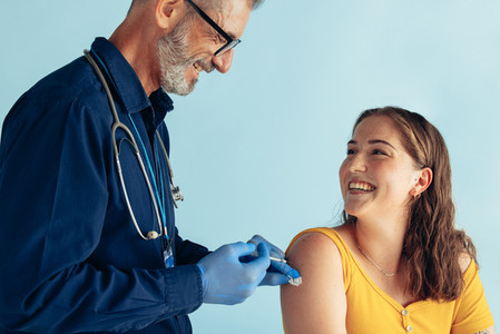 Friendly doctor giving vaccine to woman