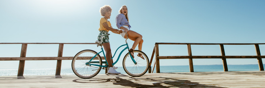 Panorama of joyful friends enjoying riding bicycle together
