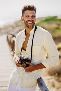 Smiling man photographing in a coastal area