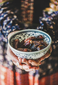Woman holding bowl of dates for Ramazan Iftar fasting meal