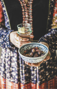 Woman holding dates and water for Ramazan Iftar meal