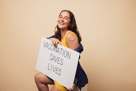 Woman holding a Vaccination Saves Lives banner