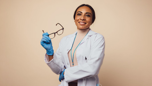 Happy female physician on brown background