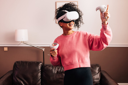 Young woman having fun with VR set Smiling female using a virtual reality headset