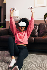 Happy woman in casual clothes raise hands up holding joysticks from VR set
