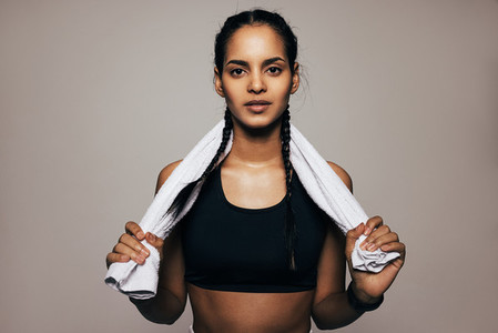 Close up portrait of a mixed race woman in sportswear holding a white towel