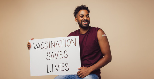 Man holding Vaccination saves lives placard