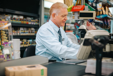 Senior cashier working at grocery store
